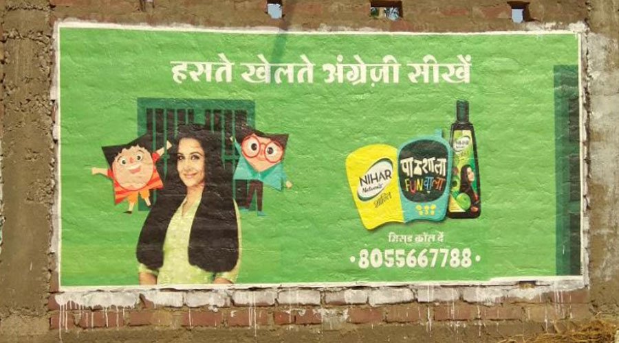 Digital wall paintings on a public wall in India, showcasing a colorful advertisement with bold graphics and Hindi text, used for outdoor brand promotion.