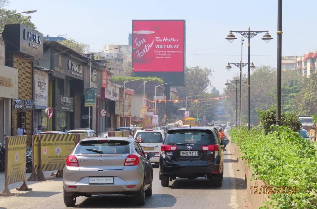 Highway hoarding displaying a bold brand ad along a busy road