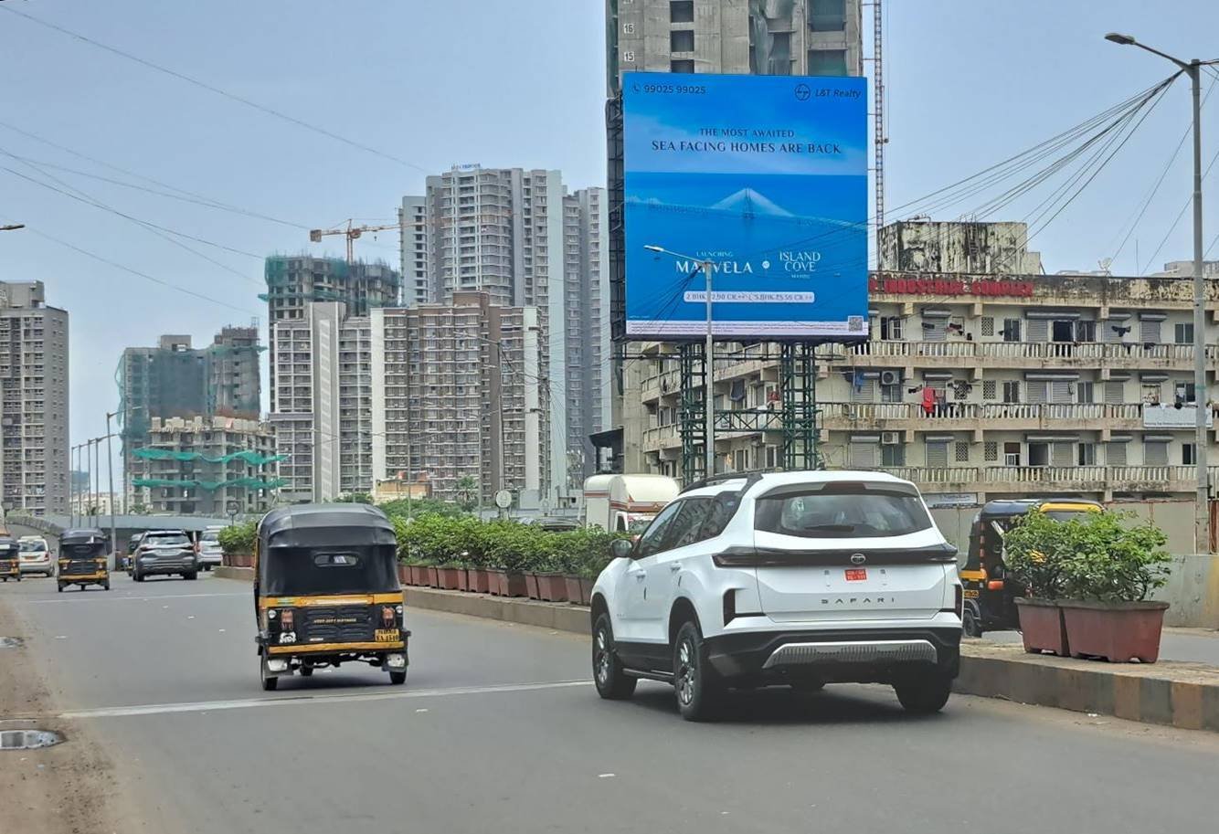 Highway hoarding displaying a bold brand ad along a busy road