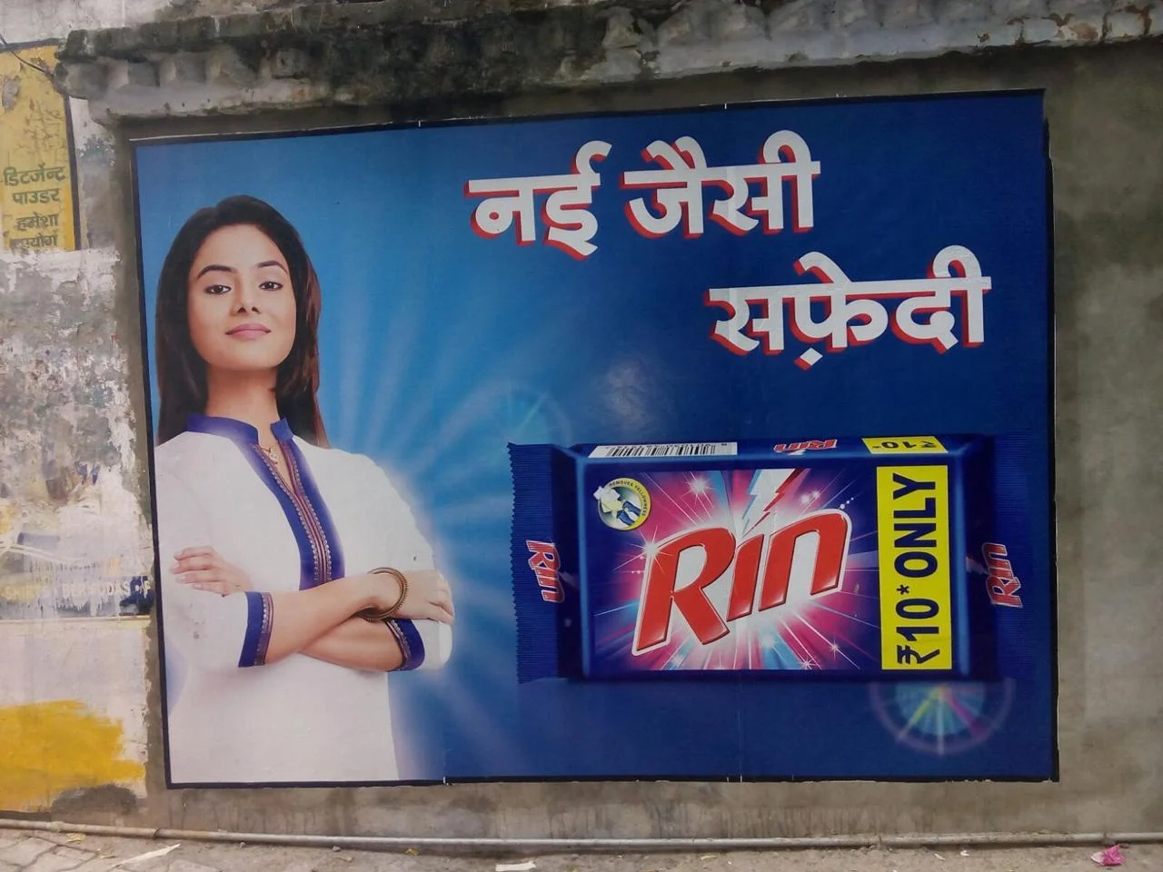 Digital wall paintings on a public wall in India, showcasing a colorful advertisement with bold graphics and Hindi text, used for outdoor brand promotion.