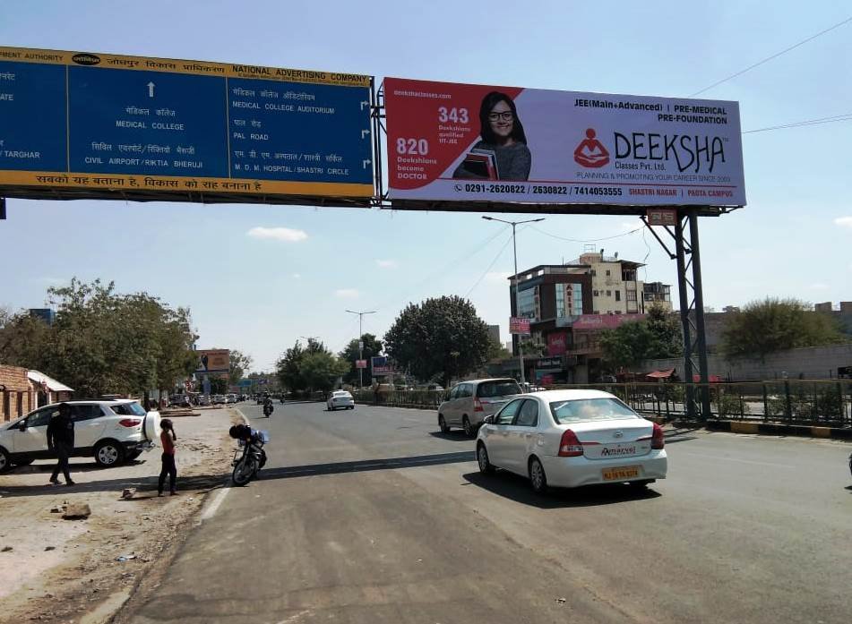 Gantry hoarding over a busy urban road displaying a large ad