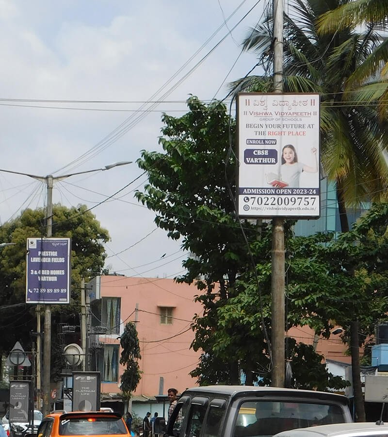 Pole kiosk advertisement by ACME Advertising Co. displayed on a busy city street for high local visibility and brand promotion.