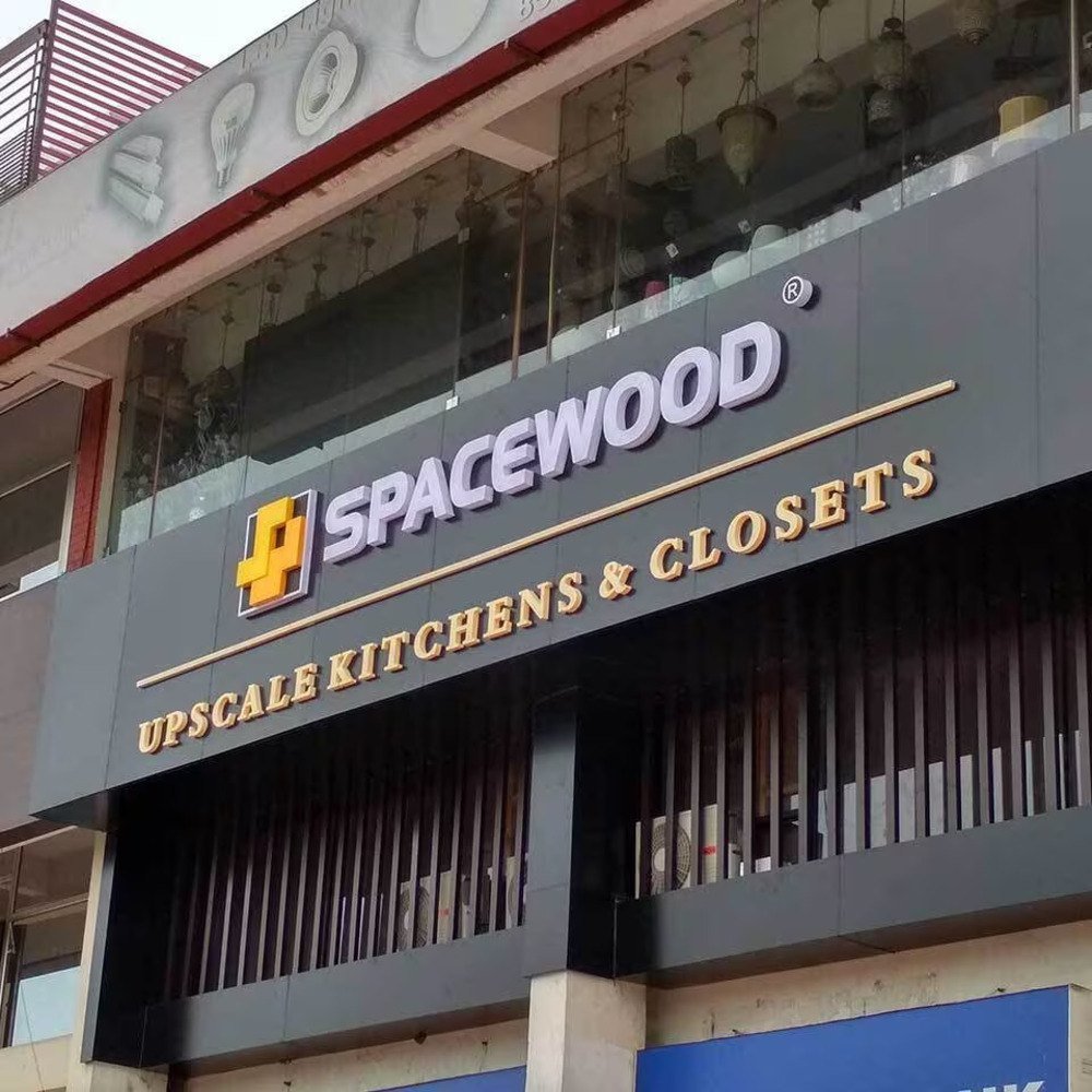 "Modern commercial building facade featuring a large 3D acrylic and metal signage board for a kitchen and closet showroom, mounted above a glass-fronted retail space."