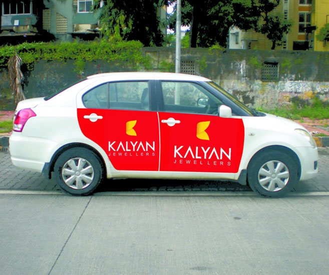 "Kalyan Jewellers cab branding on Swift Dzire – taxi wrap campaign by ACME Advertising in Delhi NCR."