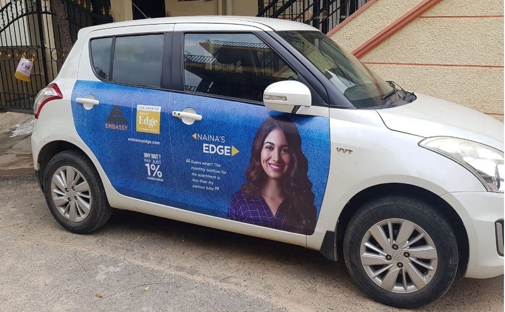 “Embassy Edge real estate cab branding in Bangalore executed by Acme Advertising Co., featuring a woman with message about 1% apartment payment plan.”